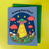 Colorful greeting card with UFO and mushrooms design with the tagline "Beaming Good Vibes!"
